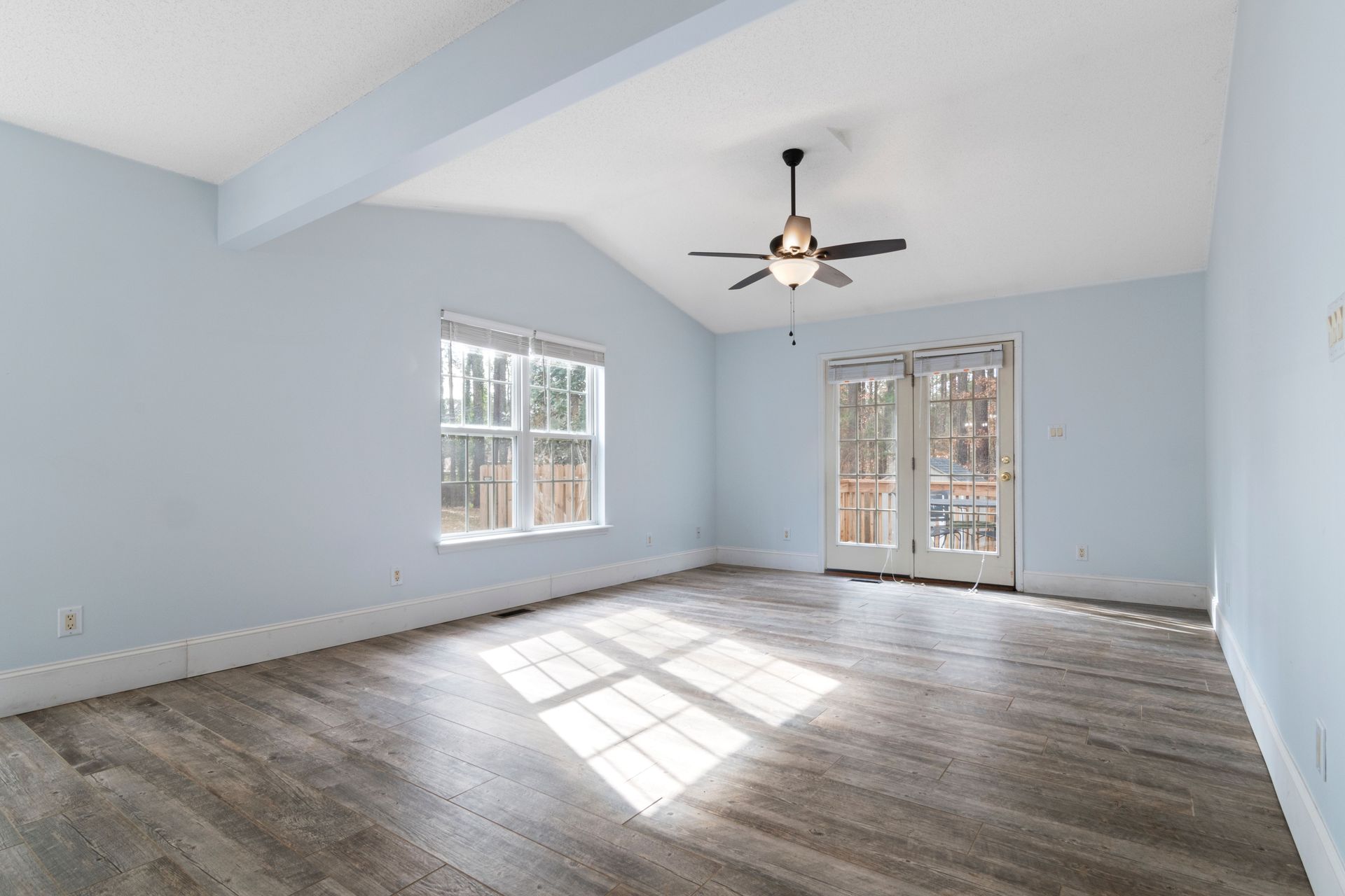 Modern empty room with blue walls and ceiling fan, ideal for interior design inspiration.